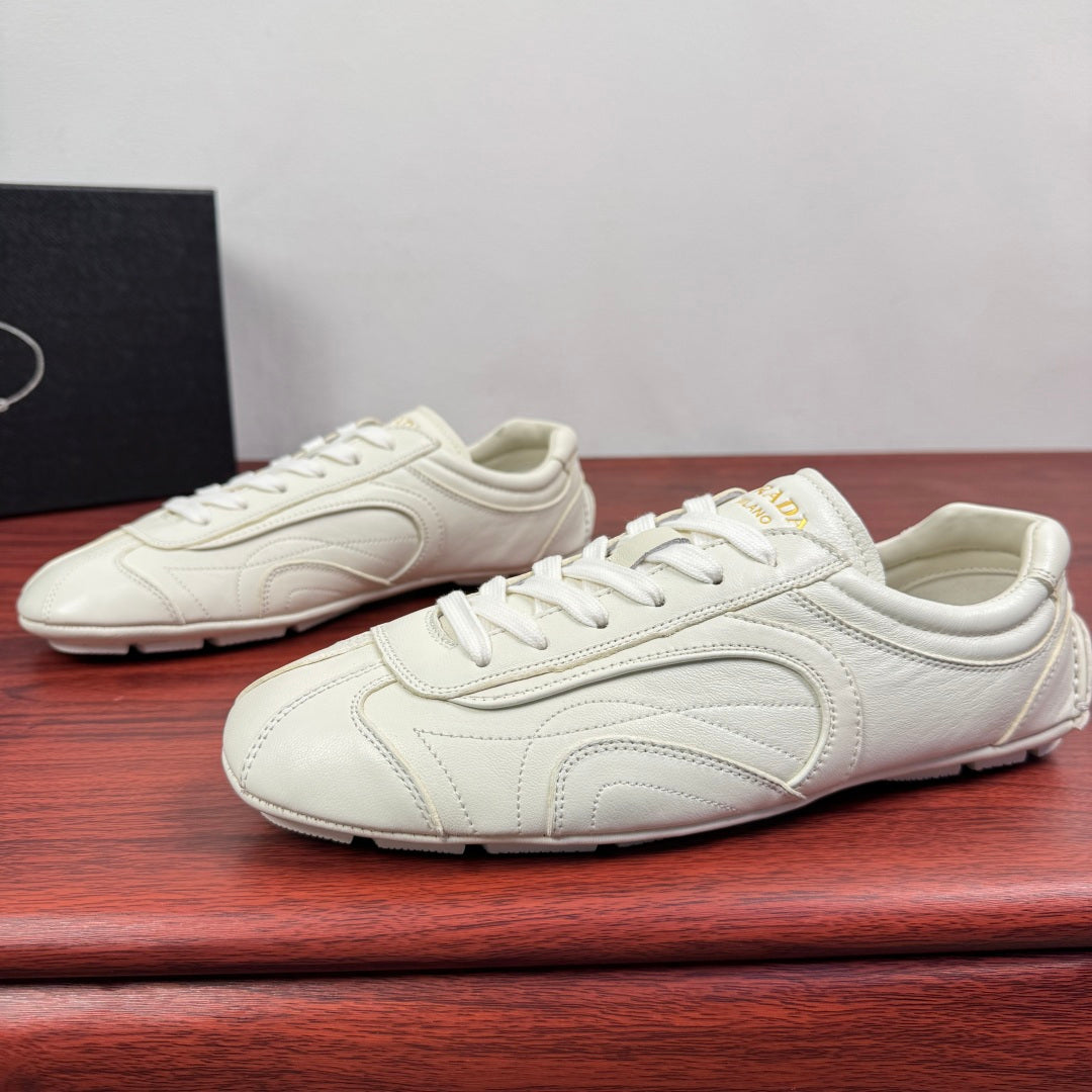 White leather lace-up sneakers with stitched toe cap and low-profile shape