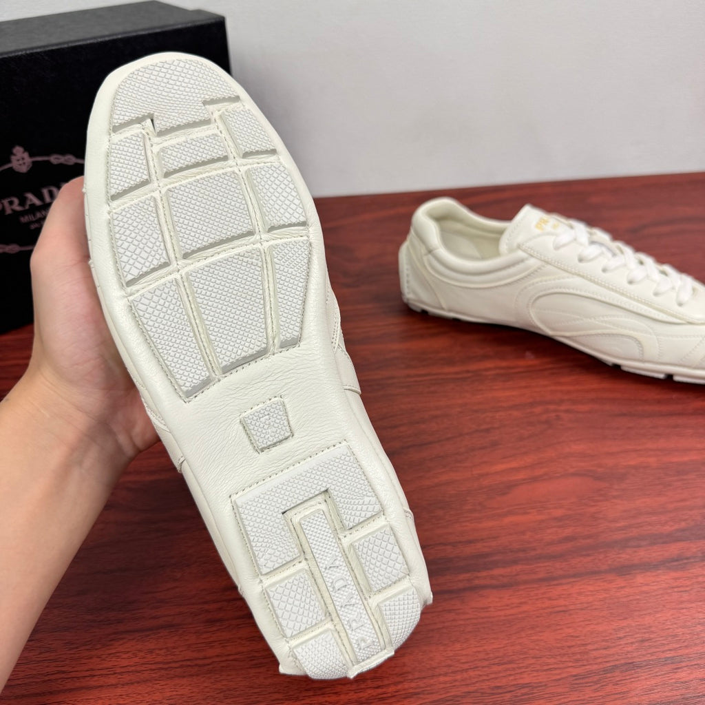 White sneaker outsole with geometric traction tread, held up for view