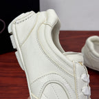 White leather lace-up sneakers close-up of heel and stitched panel details