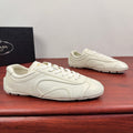 White leather lace-up sneakers with curved side seams and smooth toe cap