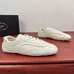 White leather lace-up sneakers with curved side seams and smooth toe cap