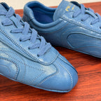 Light blue unisex sneakers close-up showing laces and stitched panel lines