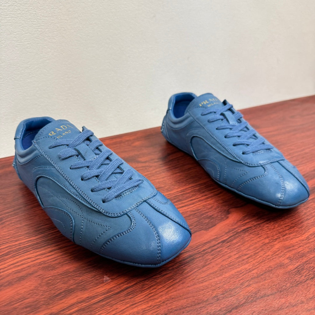 Light blue unisex lace-up sneakers with rounded toe and stitched overlays