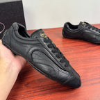 Prada unisex sneakers, close side view, dark leather with logo patch and laces