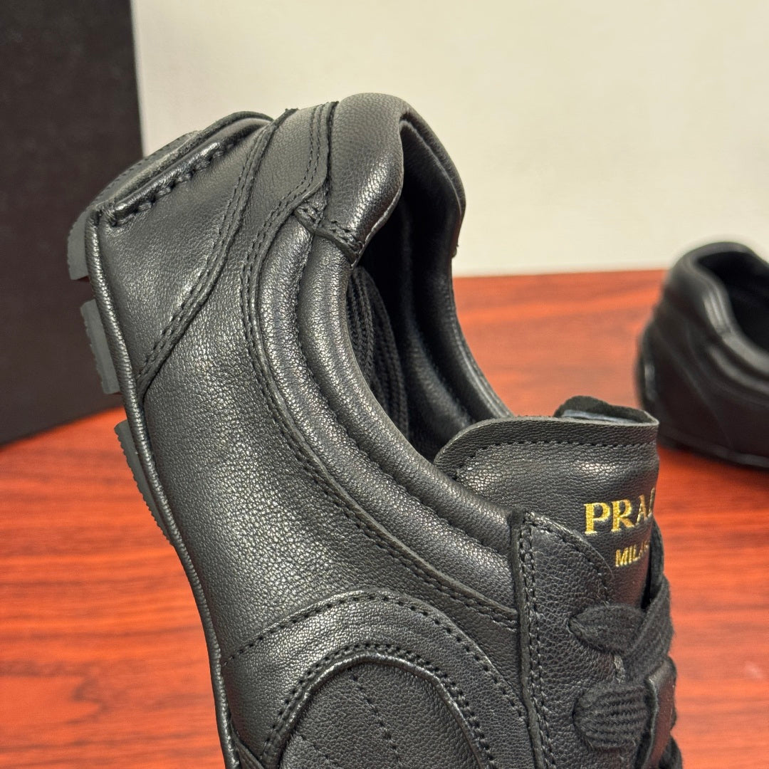 Prada unisex sneakers, close-up of side heel, textured dark leather and logo patch