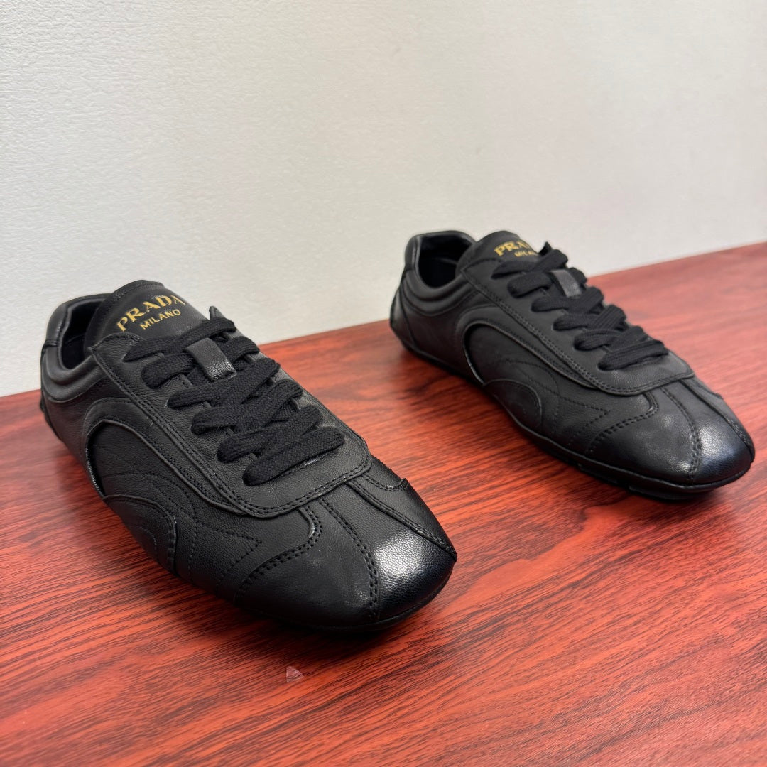 Prada unisex sneakers, side view, dark leather uppers with lace-up closure
