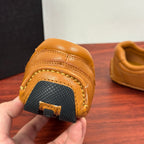Tan sneaker heel underside with textured rubber tread and stitched edge