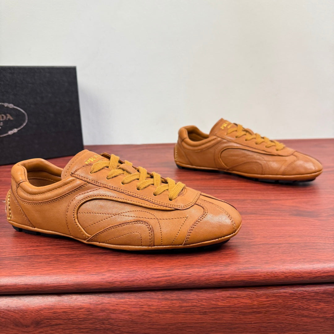 Tan Prada unisex sneakers with yellow laces and stitched panel details