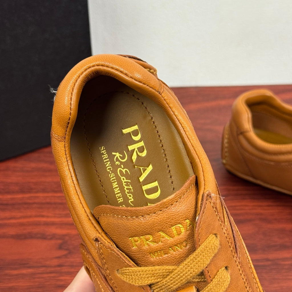 Tan sneaker interior with Prada branding on the insole and yellow laces