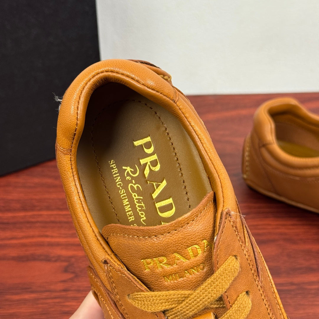 Tan sneaker interior with Prada branding on the insole and yellow laces