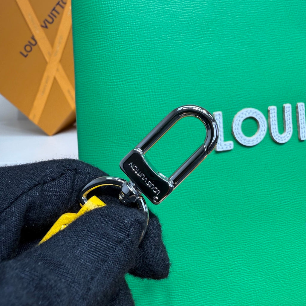 Louis Vuitton green tote bag with silver D-ring clasp and yellow strap