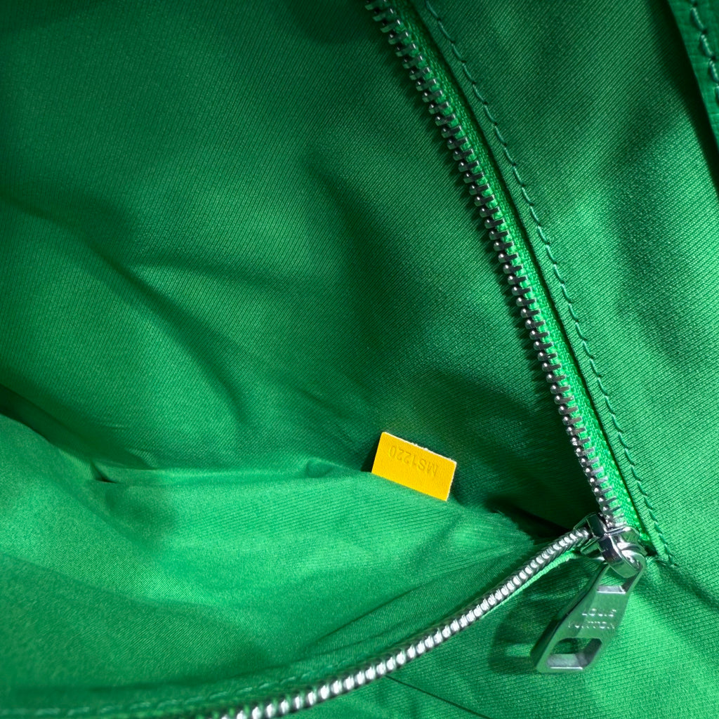 Green leather zip bag with silver zipper and small yellow label