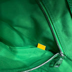 Green leather zip bag with silver zipper and small yellow label