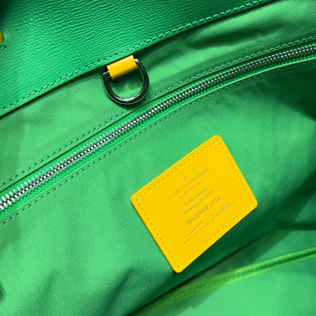 Louis Vuitton green tote bag close-up of zipper and yellow brand label