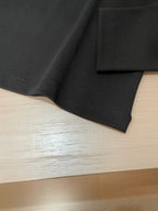 Black long-sleeve shirt with stitched hem and side seam detail