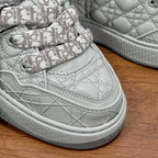 White low-top sneaker with Dior monogram laces, stitched detailing, and textured sole