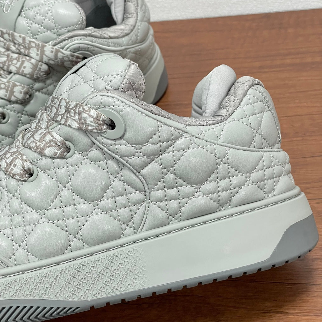Dior low-top sneaker side view, white quilted leather with logo laces and thick sole