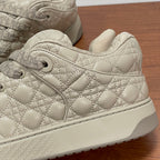 Close-up of beige quilted lace-up sneaker with textured toe and side panel