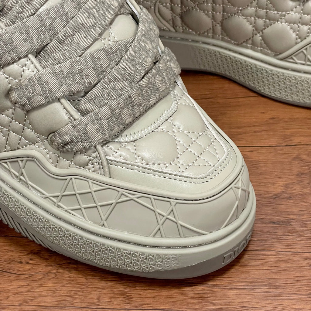 Close-up of cream sneaker sole with geometric traction pattern and lace strap