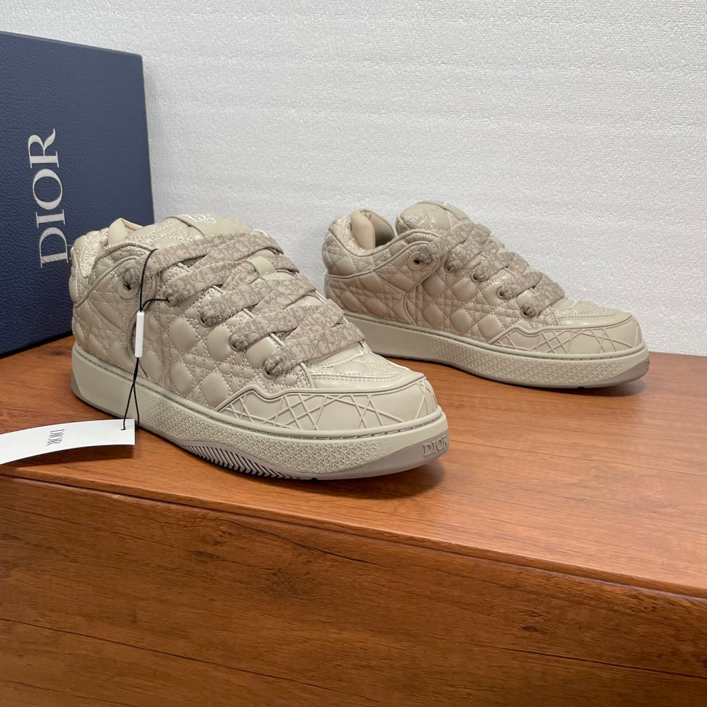 Pair of beige quilted sneakers with lace-up design and low profile rubber sole