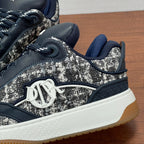 Side view of Dior sneaker with silver tweed upper, navy trim, and white midsole