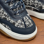 Unisex sneaker bottom view, navy leather, silver-speckled panels, white sole with gum edge