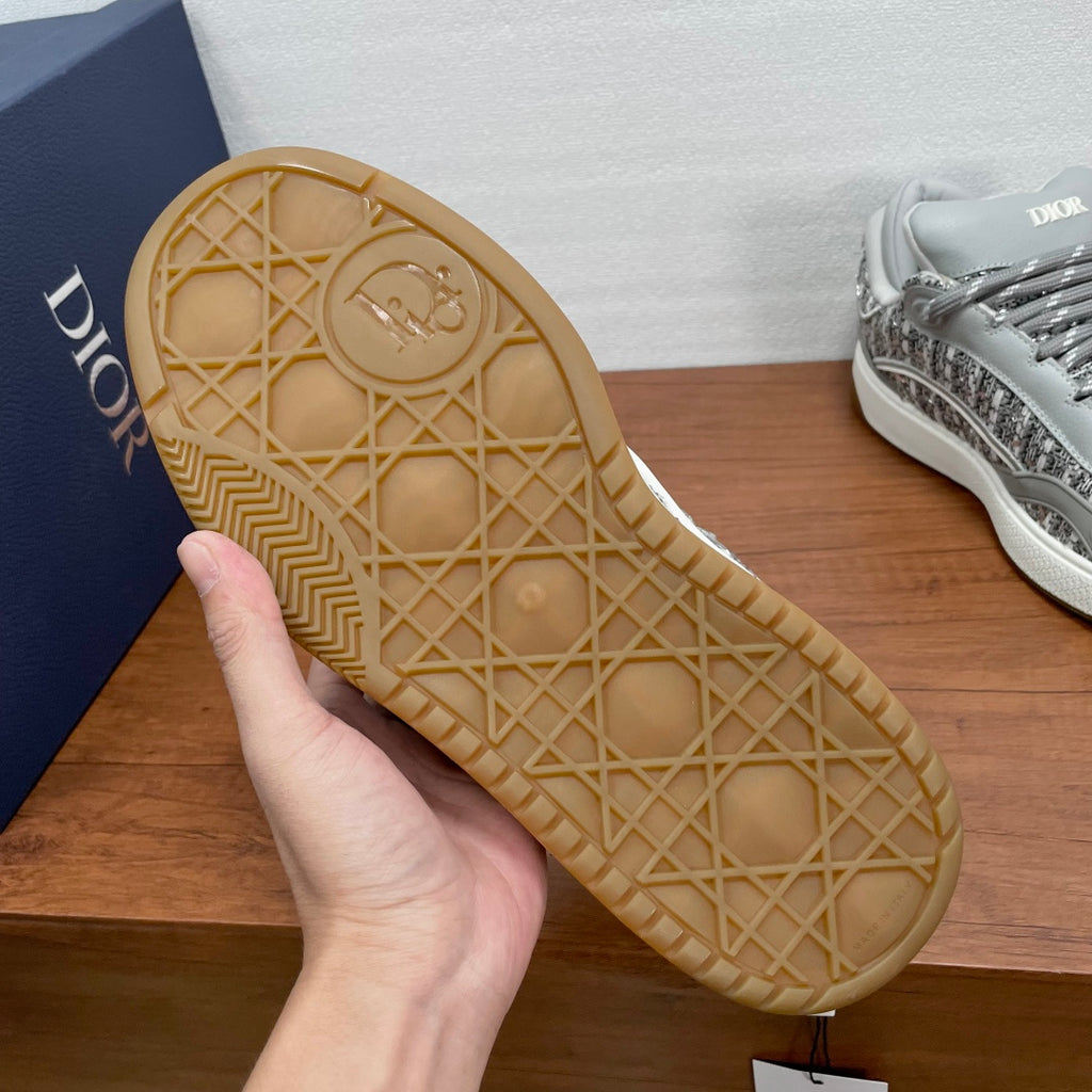 Light gray sneaker outsole with geometric tread pattern held in hand