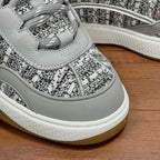 Light gray lace-up sneaker with braided laces and patterned upper detail