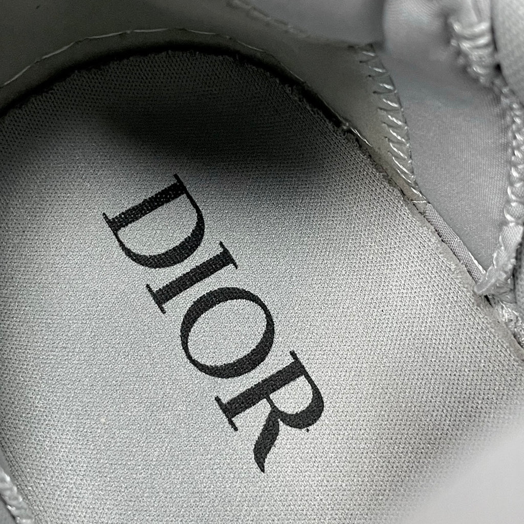 Black Dior lettering on light gray fabric lining with stitched edge