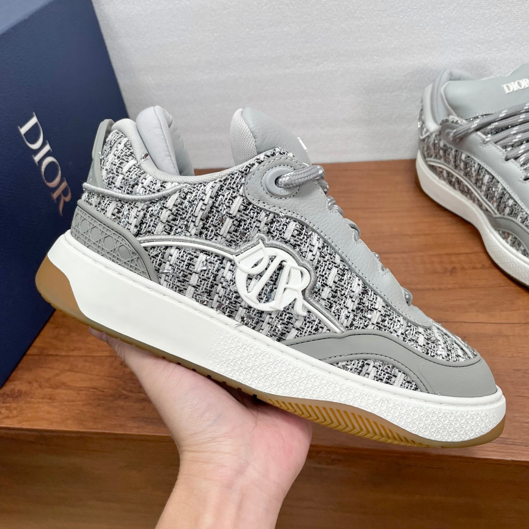 Light gray low-top sneakers with patterned upper and white outsole with gum edge