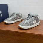 Pair of light gray low-top sneakers with silver Dior logo and textured pattern