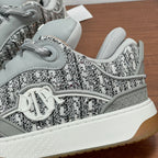 Light gray sneaker toe with textured woven upper, laces, and white sidewall sole