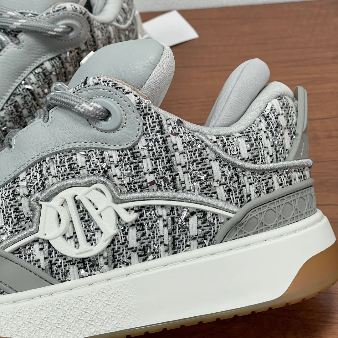 Light gray sneaker toe with textured woven upper, laces, and white sidewall sole