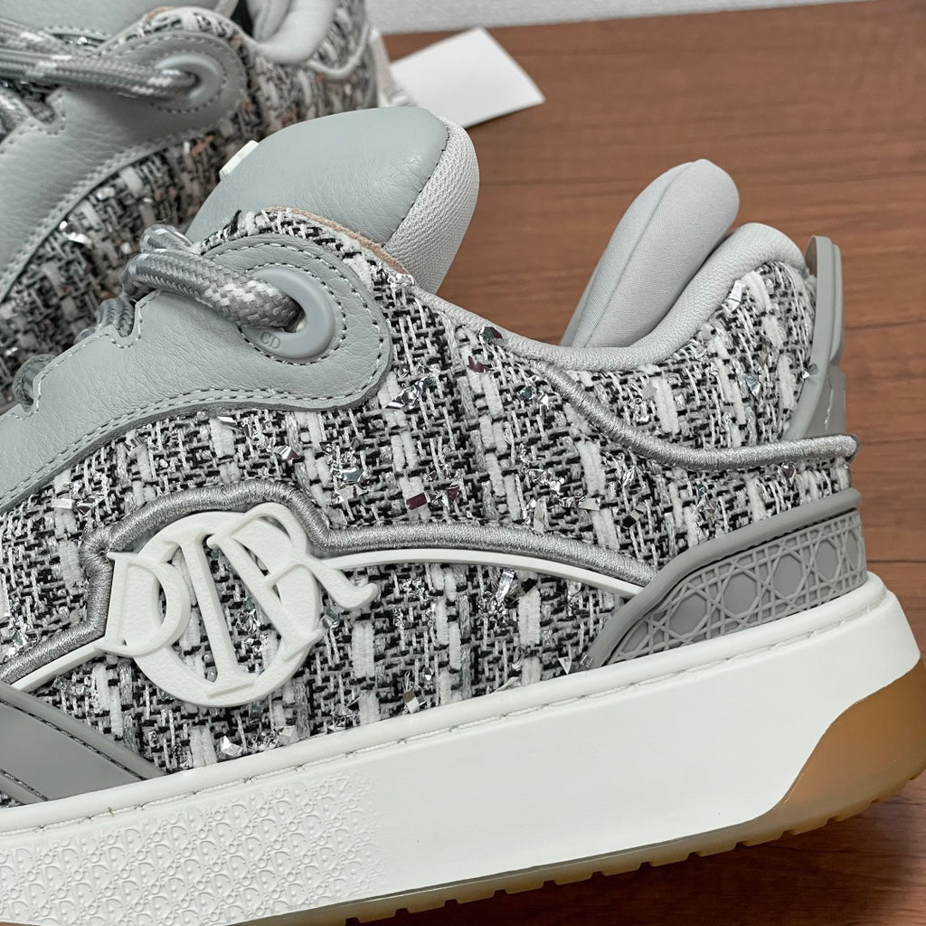 Dior unisex sneakers, close-up of tweed upper with silver V emblem and thick sole