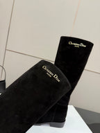 Black suede boots upper shaft close-up with gold “Christian Dior” branding