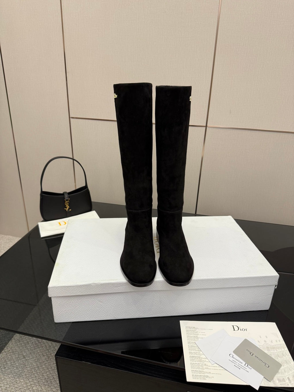 Knee-high suede boots in black on a white box, rounded toe, block heel