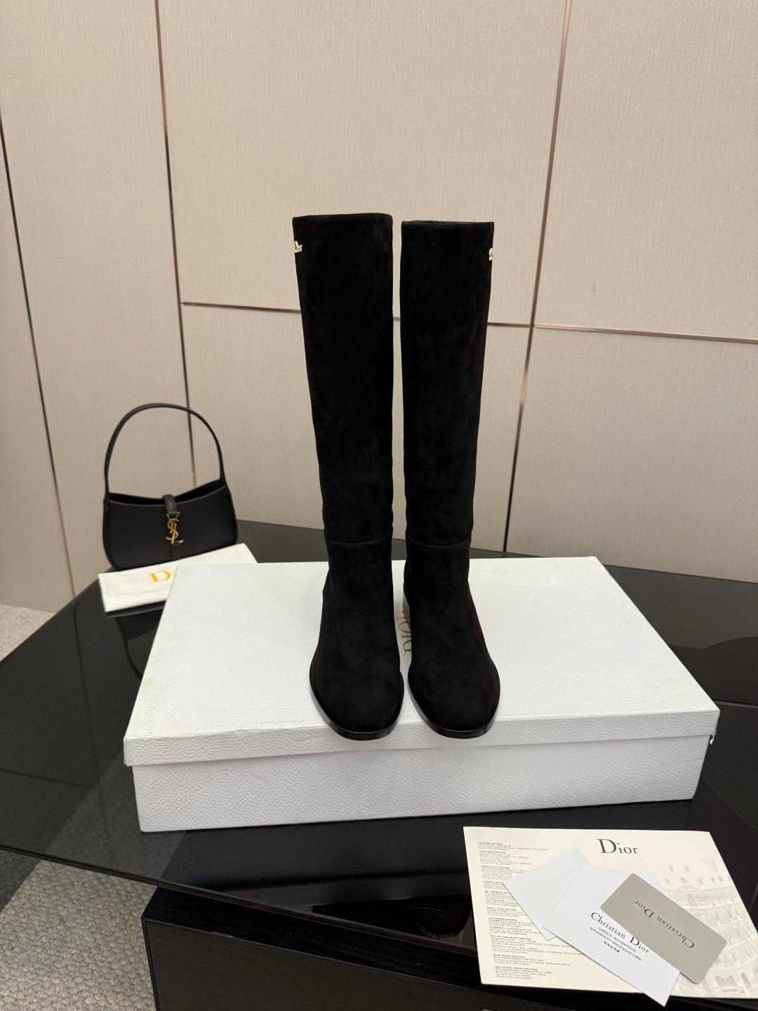Knee-high suede boots in black on a white box, rounded toe, block heel