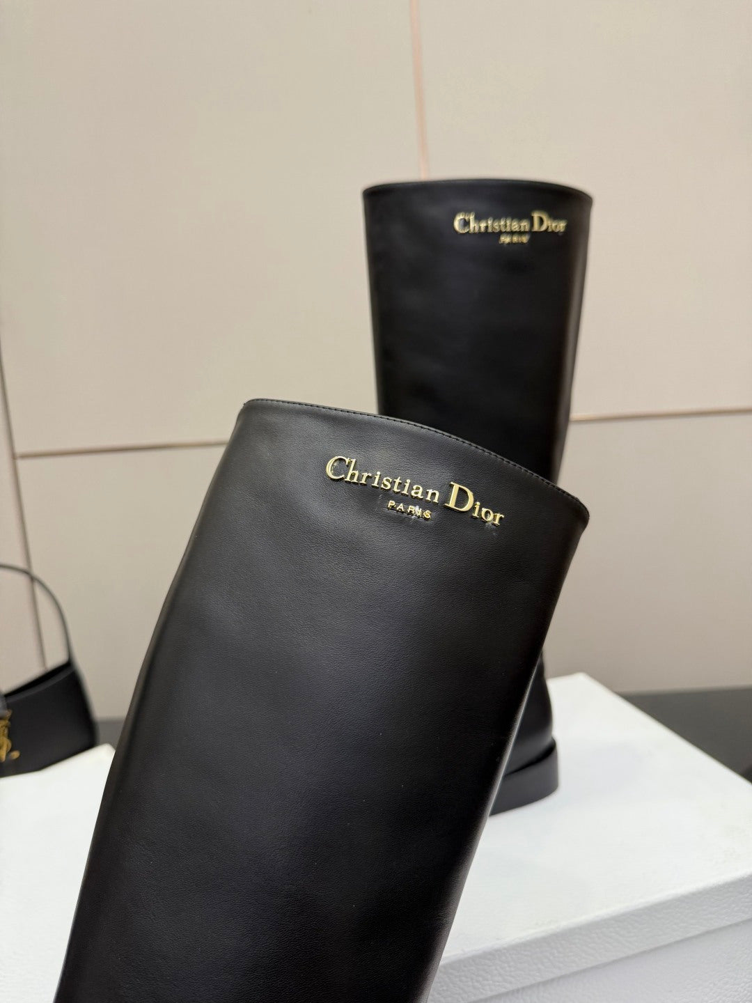Black leather knee-high boot with embossed Christian Dior text on shaft
