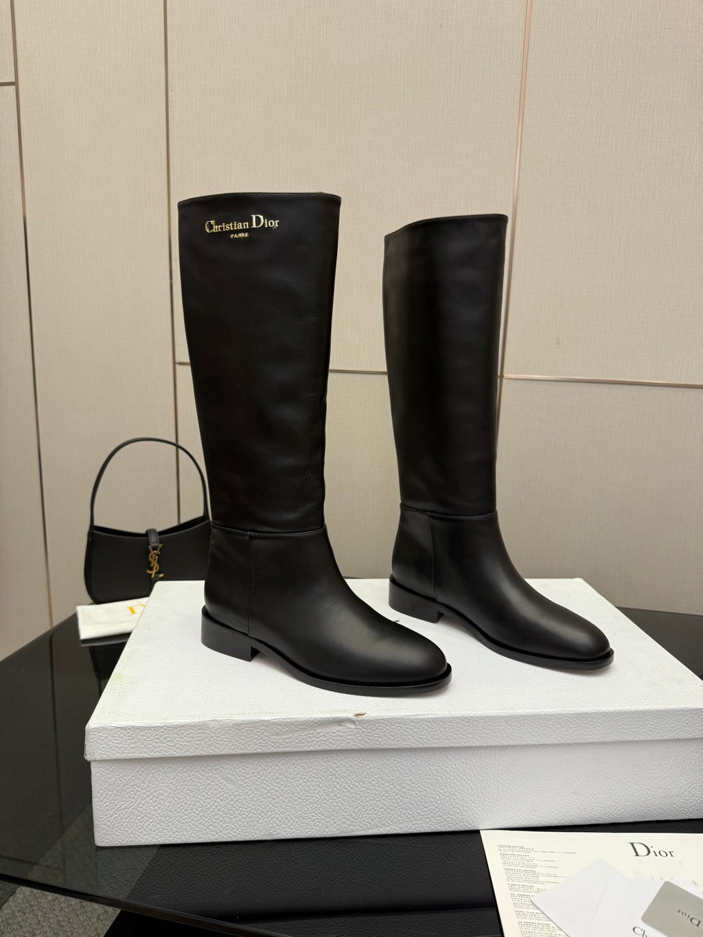 Pair of black leather knee-high boots, side view with low block heel