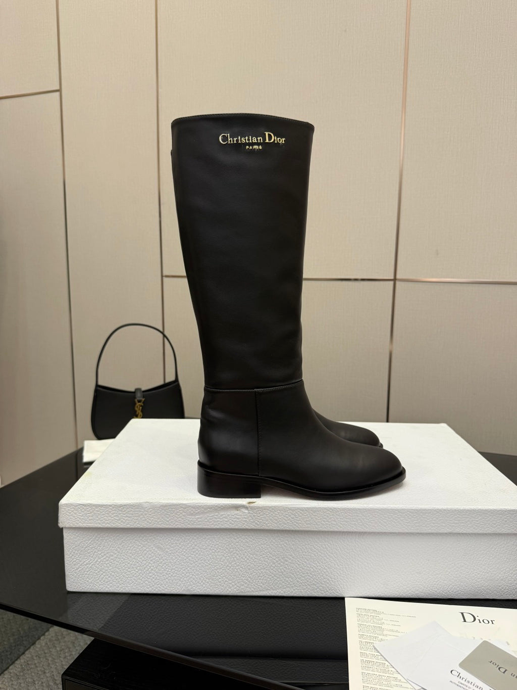 Black leather knee-high boot, pull-on style with logo at top