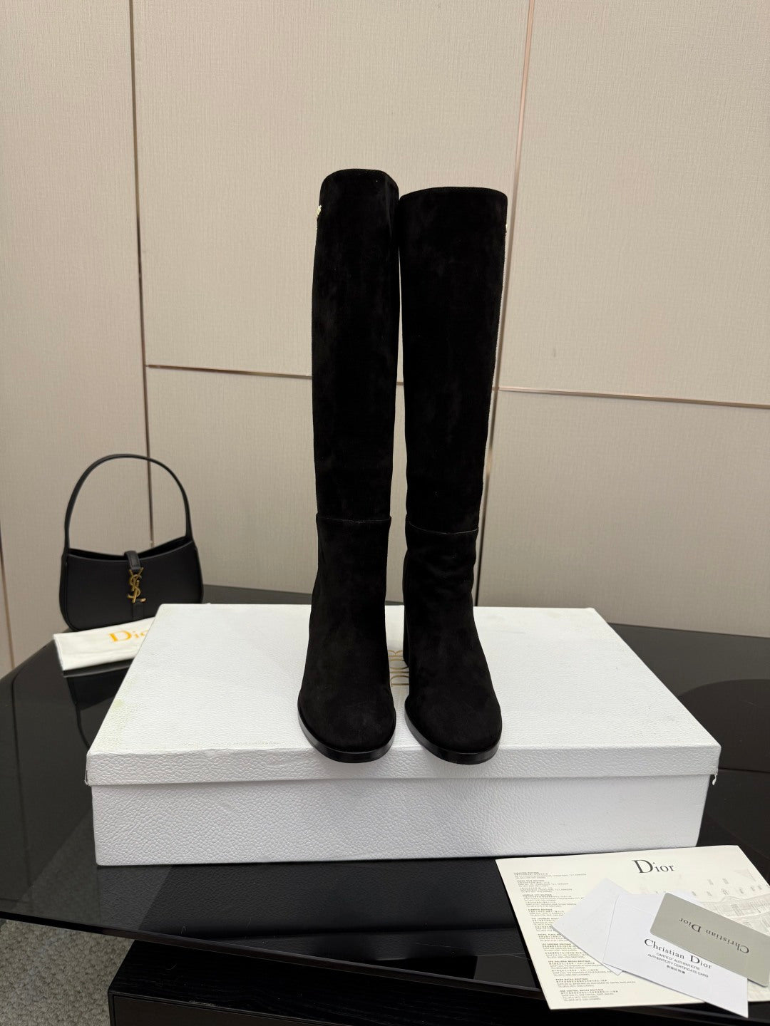 Two black knee-high suede boots with high shafts and chunky block heels