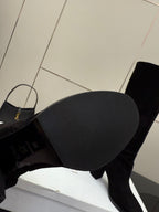 Close-up of the tread sole of a black heeled knee-high boot
