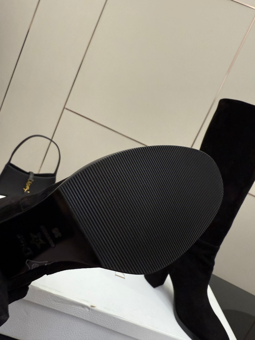 Close-up of the tread sole of a black heeled knee-high boot