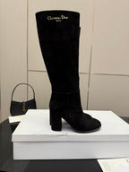 Black knee-high suede boot with high shaft and block heel, shown front view