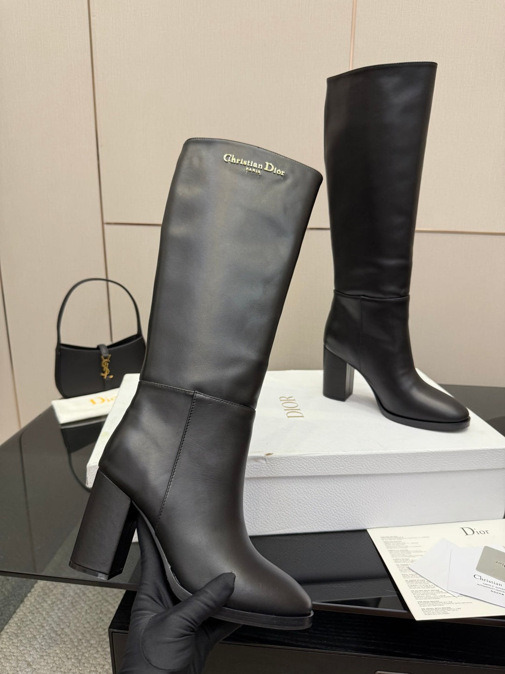 Two black knee-high boots on a box, block heels, pull-on style, Dior logo