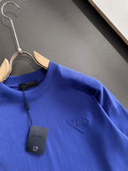 Prada blue long-sleeve top on hanger with PRADA MILANO patch and tag