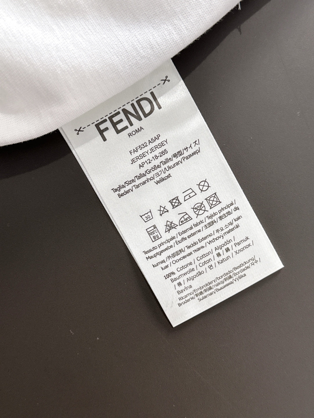 Care label tag on white long-sleeve shirt with FENDI branding