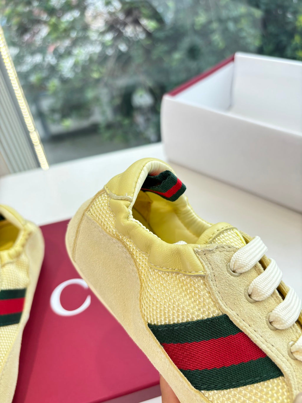 Close-up of women's yellow sneaker upper with Web stripe and striped collar