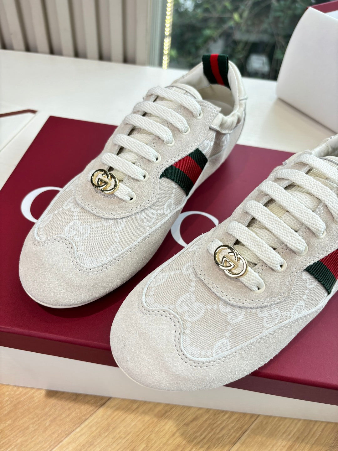 Gucci low-top sneakers close-up, white GG pattern, green-red stripe and gold logo