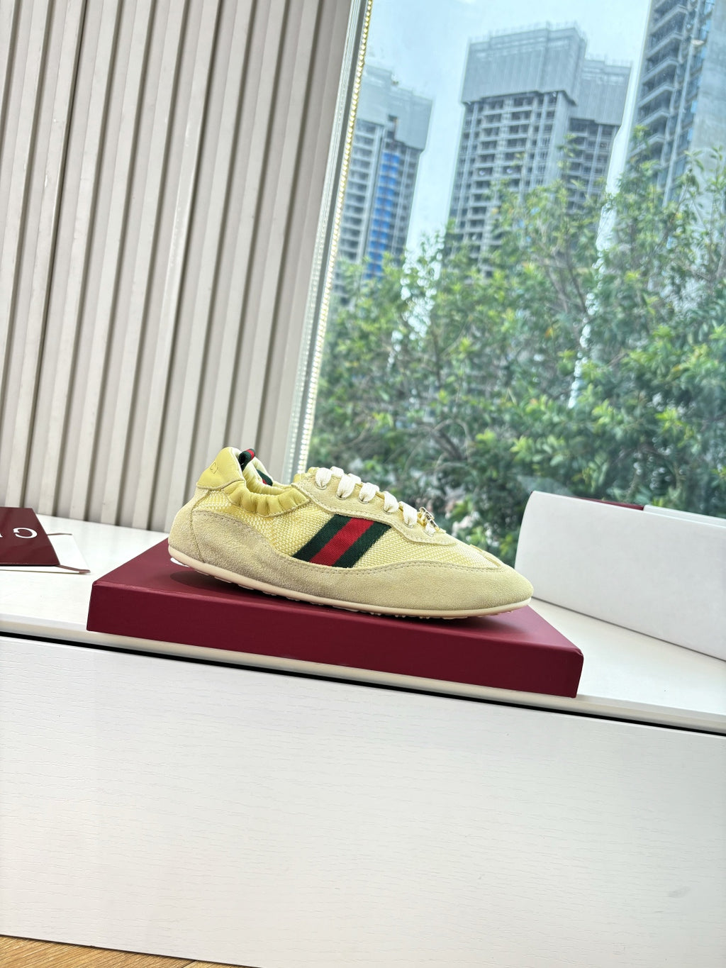 Women's yellow low-top sneakers on display, side profile with Web stripe